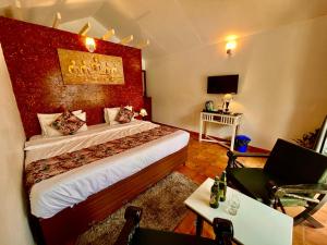 a bedroom with a large bed with a red wall at The Four Season Hotel & Cottage, Goa in Candolim