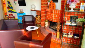 - un salon avec une cheminée en briques et une chaise dans l'établissement Best Western Spreewald, à Lübbenau