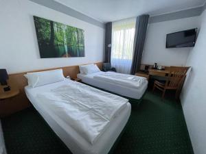 a hotel room with two beds and a desk at Best Western Spreewald in Lübbenau