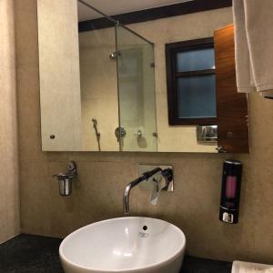 y baño con lavabo blanco y espejo. en UDS Villa Scandinavian B&B - Next to VFS en Nueva Delhi