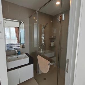 uma casa de banho com um lavatório e uma cabina de duche em vidro. em Sea View Family Room at Nuvasa Bay Resort em Nongsa