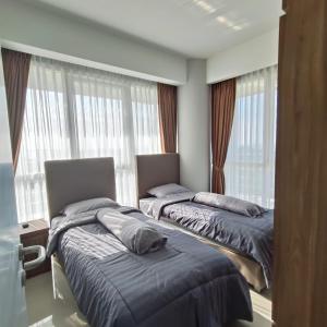 two beds sitting in a room with a window at Sea View Family Room at Nuvasa Bay Resort in Nongsa