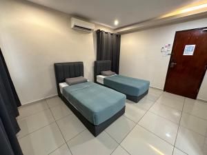a room with two beds and a door at HOTEL APOLLO KAMPUNG BENGGALI in Butterworth