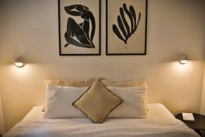 um quarto com uma cama com três fotografias na parede em Loft 2D2B con Terraza en el Corazon de Santiago em Santiago