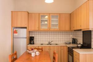 una cucina con mobili in legno e un tavolo in legno di Pool Apartments with panoramic Pelekas Beach view a Pelekas