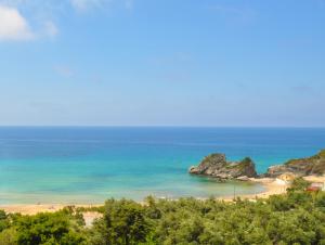 a view of a beach with rocks in the ocean at Pool Apartments with panoramic Pelekas Beach view in Pelekas