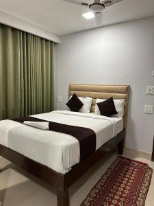a bedroom with a large bed with white sheets at Chauhan Hospitality IGI Airport New Delhi Mahipalpur in New Delhi