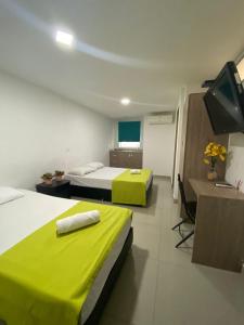 a hotel room with two beds and a flat screen tv at Emporium Medellín Laureles in Medellín