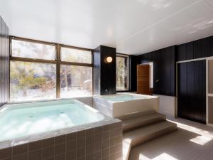 a bathroom with a large tub and a large window at TabistKitami Athlete Stays in Kitami
