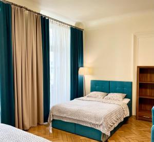 a bedroom with a blue bed and a window at Apartamenty i Studia HERBARIUM in Krakow