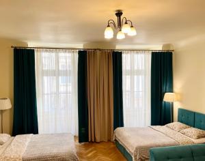sypialnia z 2 łóżkami i 2 dużymi oknami w obiekcie Apartamenty i Studia HERBARIUM w Krakowie