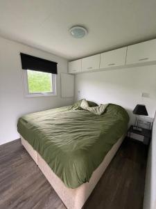 Schlafzimmer mit einem Bett und einem Fenster in der Unterkunft Camping Wad noch Meer in Anna Paulowna