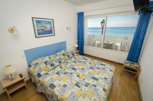 a bedroom with a bed and a view of the ocean at Hotel L'ondine in Algajola