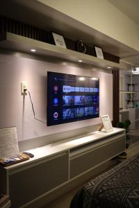 En TV eller et underholdningssystem på Azure North at J&M Staycation City lights and Mt Arayat view