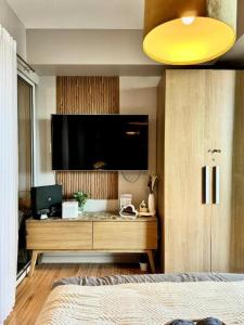 a bedroom with a flat screen tv on the wall at Azure Urban Residences Beach and Resort by Vookley in Manila