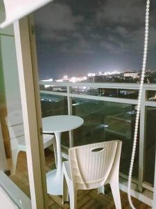 a table and chairs on a balcony with a view at Azure Urban Residences Beach and Resort by Vookley in Manila