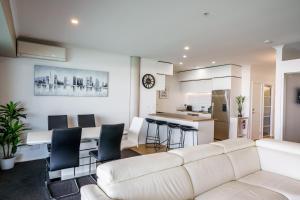 a living room with a white couch and a kitchen at Princes Wharf - Luxury in Auckland