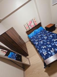 Cette petite chambre comprend un lit avec des draps bleus et blancs. dans l'établissement Shanata Suntrust, à Manille