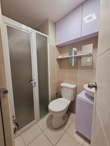 La petite salle de bains est pourvue d'une douche et de toilettes. dans l'établissement Shanata Suntrust, à Manille