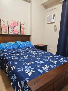 - une chambre avec un lit et une couette bleue et blanche dans l'établissement Shanata Suntrust, à Manille
