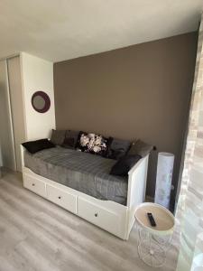 een slaapkamer met een bed met een wit bedframe bij Studio La Baleine Rose Centre Cap D'Agde in Cap d'Agde