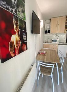 a small kitchen with a table and a dining room at Studio La Baleine Rose Centre Cap D'Agde in Cap d'Agde