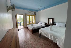 una camera d'albergo con due letti e una finestra di Blue Sunset Hostel a Vang Vieng