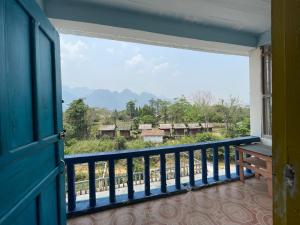 a balcony with a window and a view of a village at Blue Sunset Hostel in Vang Vieng