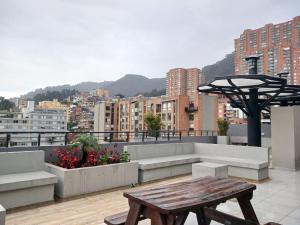 una mesa de picnic en la azotea con vistas a la ciudad en Moderno apartamento 211 en Bogotá
