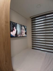 1 dormitorio con TV en la pared en Moderno apartamento 211 en Bogotá