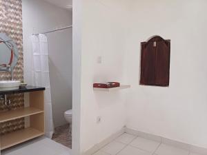 a bathroom with a shower and a toilet and a sink at Rumah Bali Kelating in Krambitan