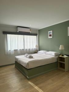 a bedroom with a large bed and a window at O'Shea's Sukhumvit Bangkok in Khlong Toei