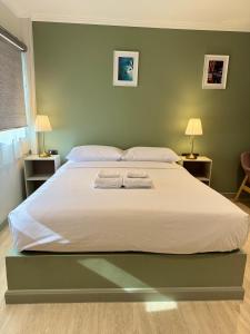 a bedroom with a large bed with two towels on it at O'Shea's Sukhumvit Bangkok in Khlong Toei