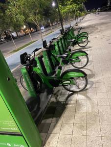 a row of green bikes parked on a sidewalk at Fatih Hostel for Males in ‘Urwah