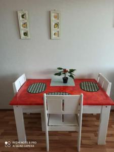 a dining room table with a red table and chairs at New home in the citycenter. in Rovaniemi