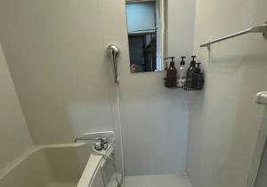 ein Bad mit einer Dusche, einem Spiegel und einem Waschbecken in der Unterkunft JapaneseTraditional house【Zushi Kotsubo ONDa】 in Zushi