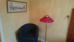 a room with a blue chair and a pink lamp at Stadshotellet Sölvesborg in Sölvesborg