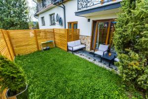 a backyard with two chairs and a fence at Chatka Gaździnek in Czarna Góra