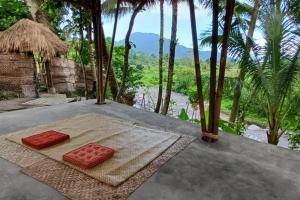 a room with two red cushions on a table with trees at Anandinii River Lodge in Sidemen