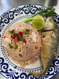 un plato de comida con arroz, pescado y lima en CTM.INN (SISAKET)THAILAND, en Ban Bua Toei