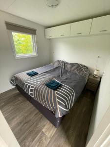 ein Schlafzimmer mit einem Bett mit blauen Handtüchern darauf in der Unterkunft Camping Wad noch Meer in Anna Paulowna