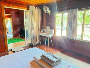 um quarto com uma cama, uma secretária e janelas em ไททำดี โฮมสเตย์ Taitam-D Homestay em Ta Phraya