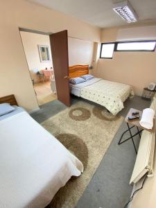 um quarto com 2 camas e uma porta com um espelho em Matta Central em Osorno