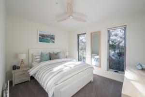 a white bedroom with a white bed and windows at You Me And The Sea Blairgowrie in Blairgowrie