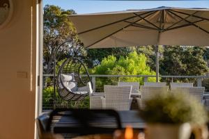 a table and chairs with an umbrella on a patio at You Me And The Sea Blairgowrie in Blairgowrie