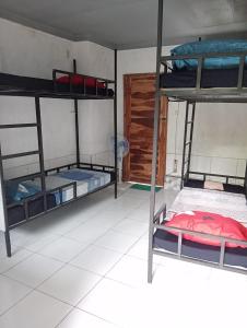 a room with three bunk beds and a door at ATB Hostel in Lovina