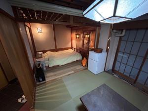 a small room with a bed and a refrigerator at 四条ホテル in Kyoto +2 photos