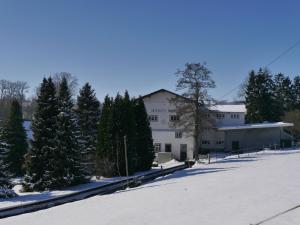 a large white building with trees in the snow at Spacious holiday home in the Teutoburg Forest in Schieder-Schwalenberg