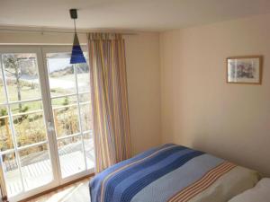 a bedroom with a bed and a large window at Lovely holiday home near the ski-area in Missen