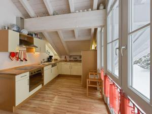 eine Küche mit weißen Schränken und einem großen Fenster in der Unterkunft Lovely holiday home near the ski-area in Missen